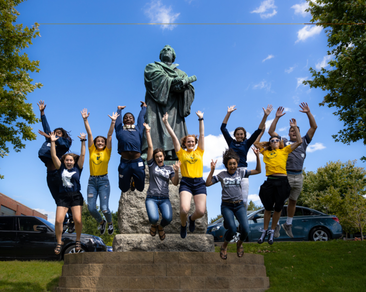 Students jump for photo in front of Martin Luther statue