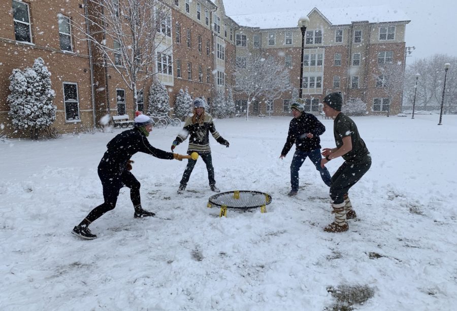 Four CSP students playing spikeball in the snow outside of Holst Hall.