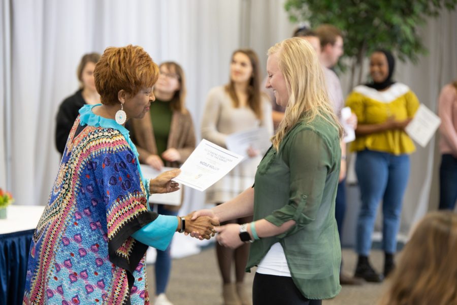 CSP Employee shaking hands with CSP Student while giving an award.