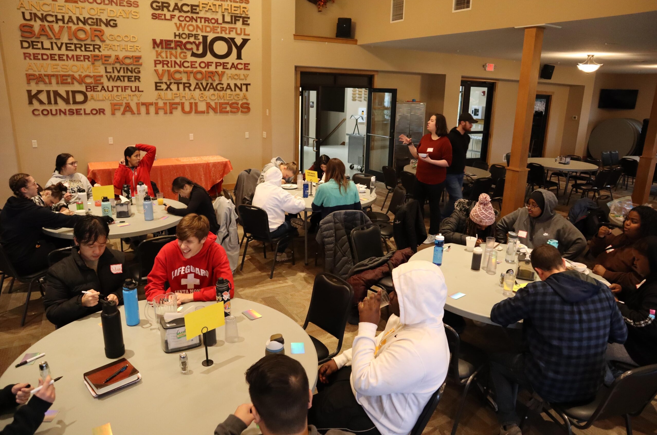 Group of peoople at round tables collaborating with others.