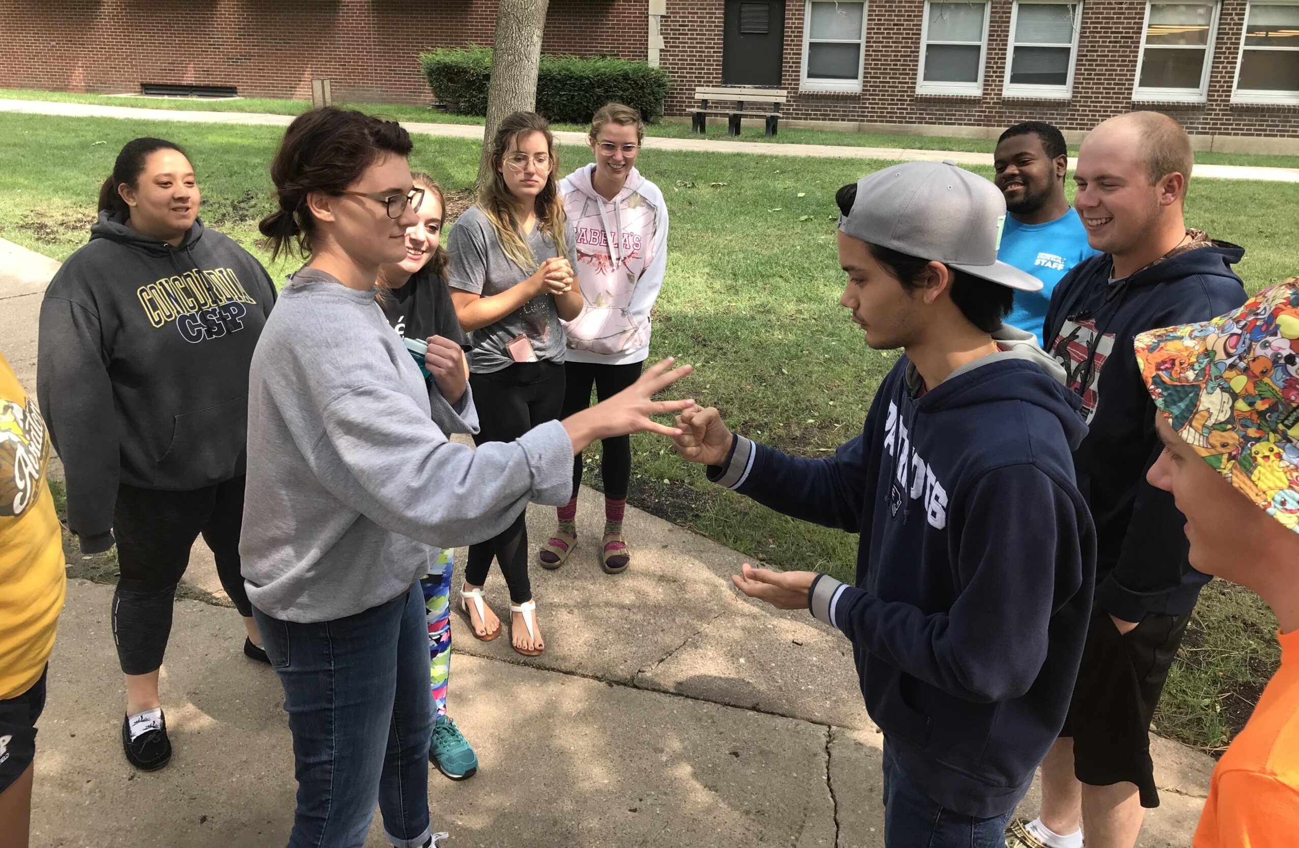 Group of students playing Rock, Paper, Scissors outside