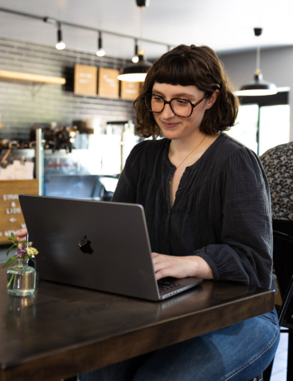 Online student using a laptop at a coffee shop.