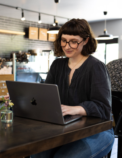 Online student using a laptop at a coffee shop.