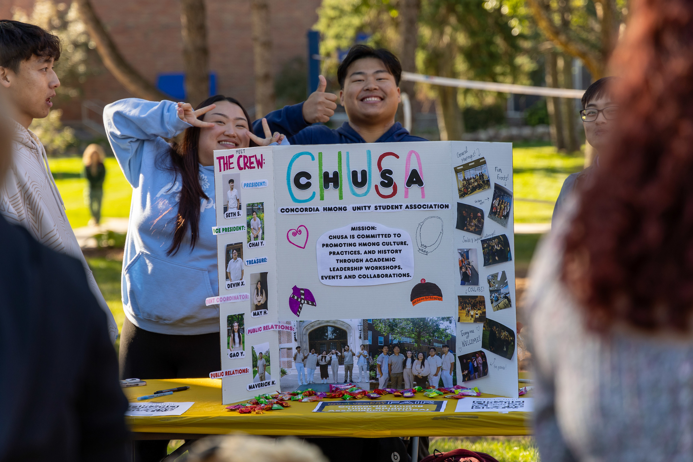 Students displaying a cardboard sign at an event outside.