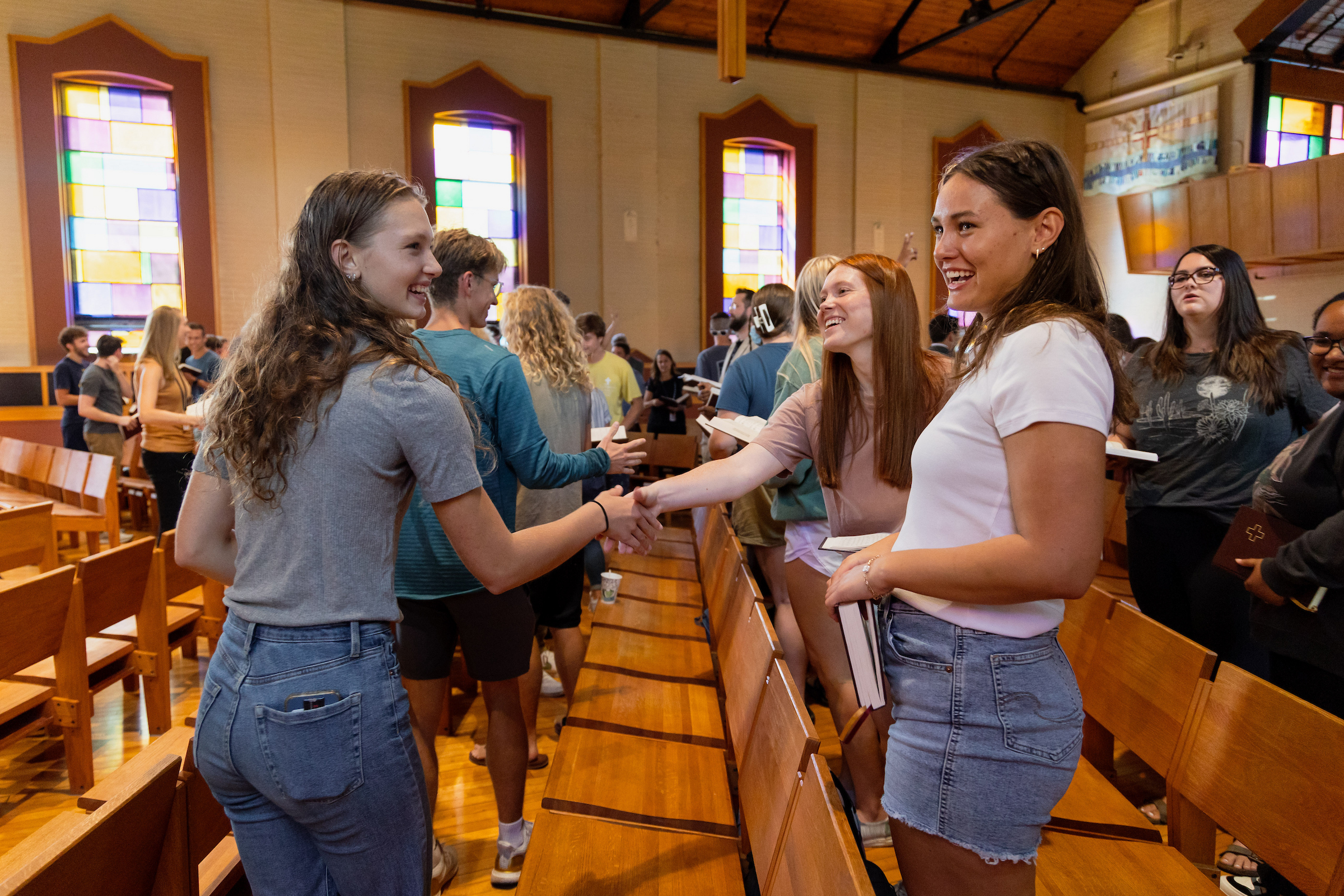Students greeting each other in chapel on Concordia's campus.
