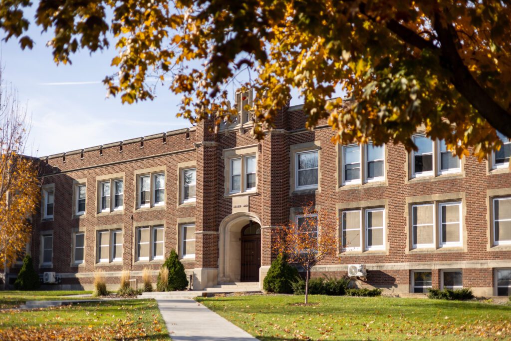 Brown and tan historic brick building on a college campus.