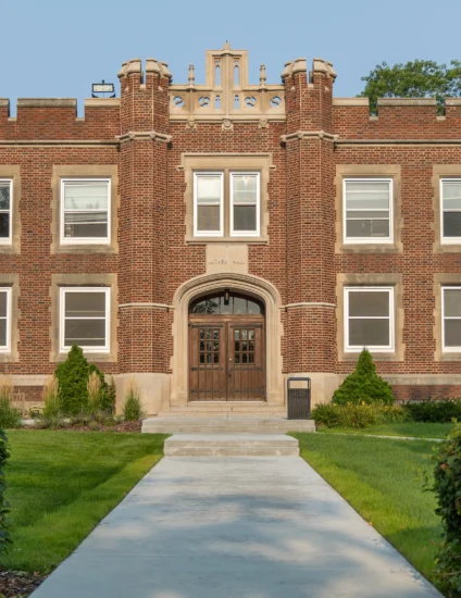 Historic brown and tan brick residence hall building on a college campus.