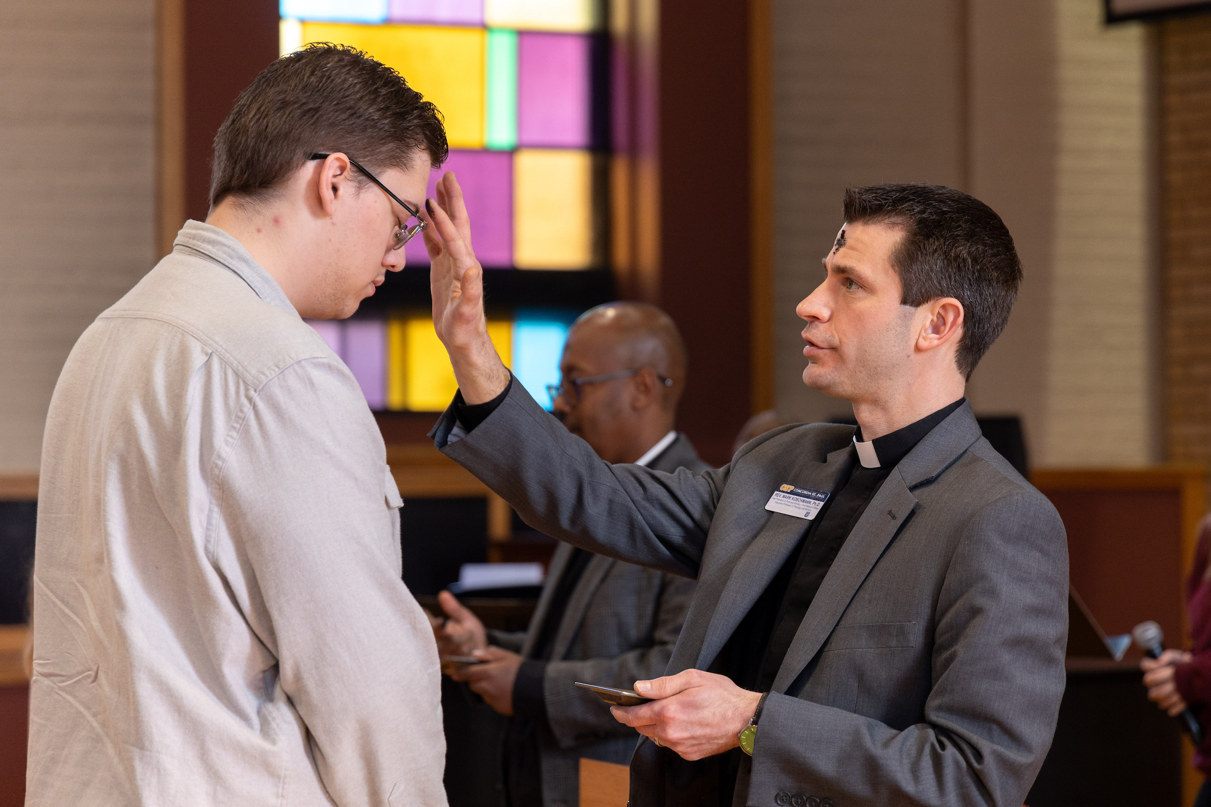 CSP employee Mark Koschmann with a student on Ash Wednesday