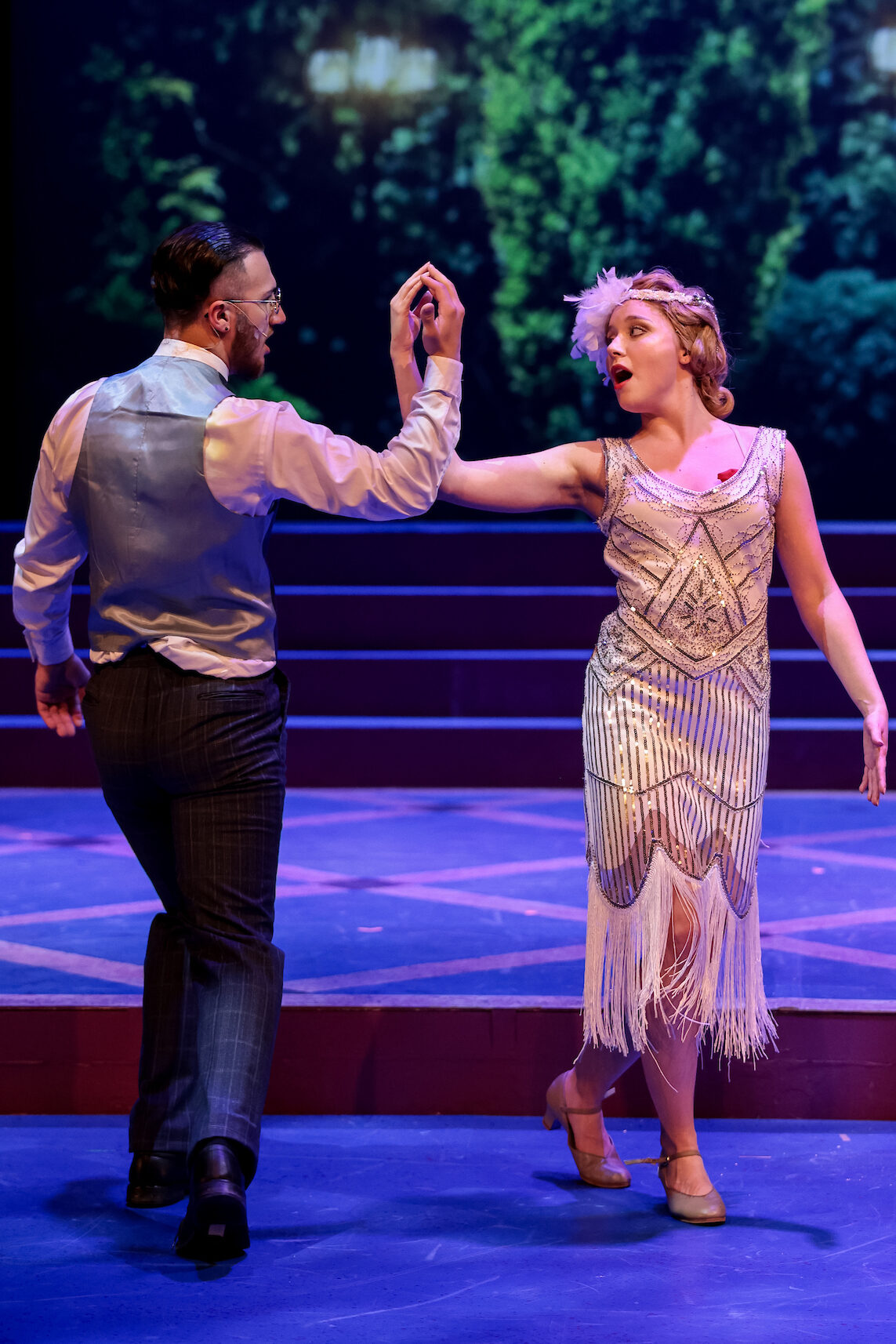 Two theatre performers singing a song on stage.