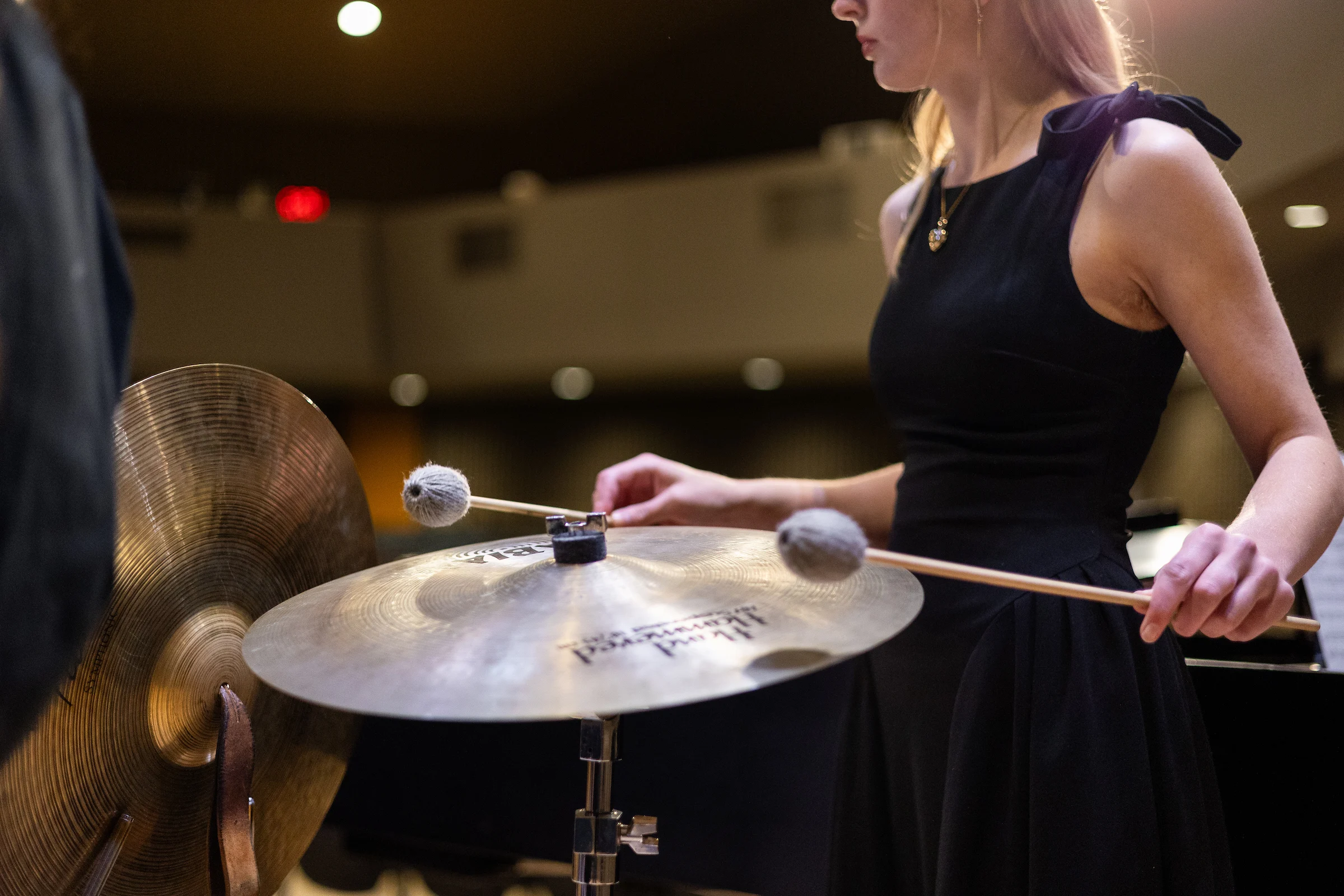 CSP band student playing the cymbal during a dress rehearsal performance.
