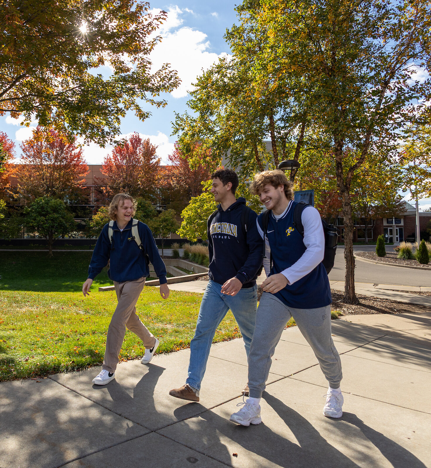 3 college students walking outside in autumn at CSP's campus.