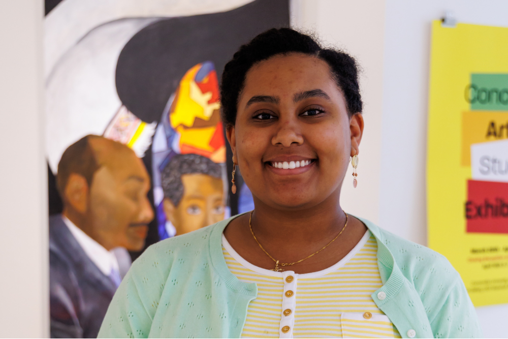 Headshot of CSP student Mikal Barnabas standing in front of art pieces.