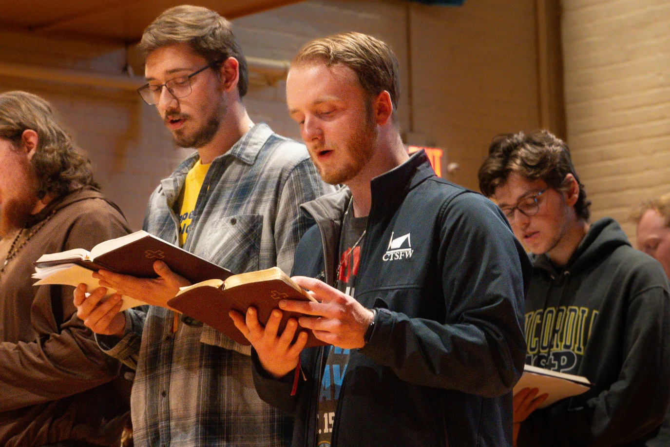 Students hold hymnals and sing in Chapel.