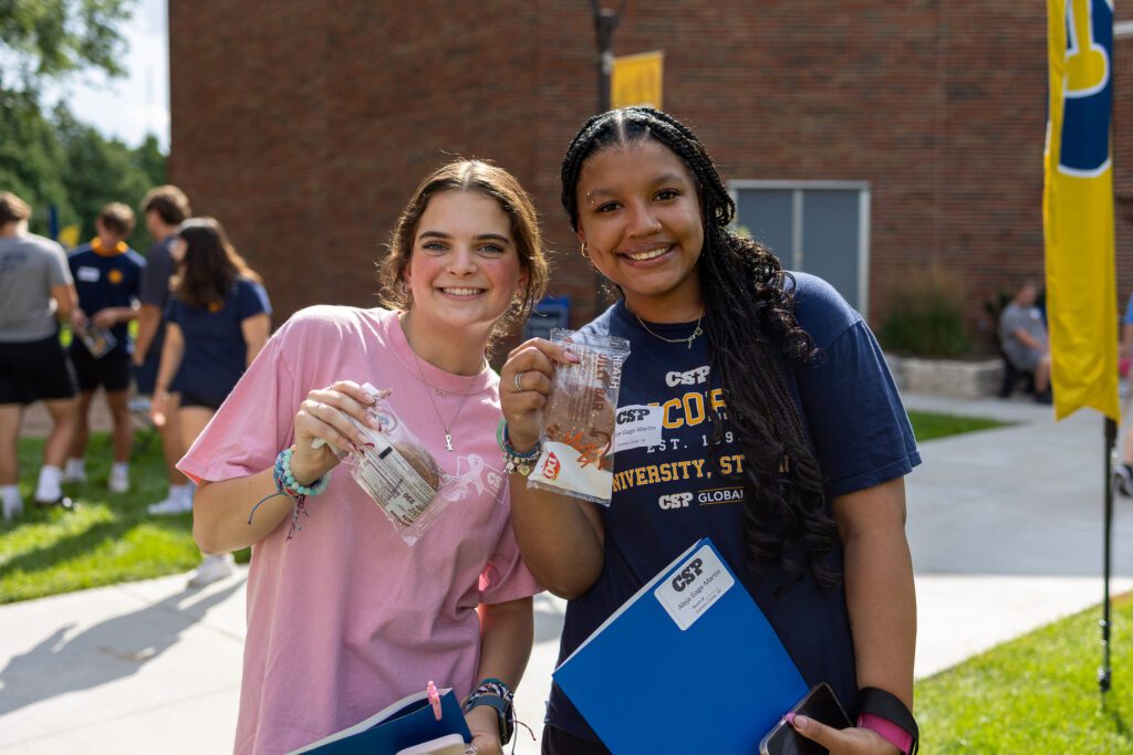 Two students holding ice cream bars at new student orientation.